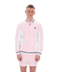 Person wearing a pink tracksuit with a FILA logo, paired with matching shorts on a white background