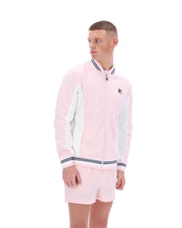 Person wearing a pink tracksuit with a FILA logo, paired with matching shorts on a white background