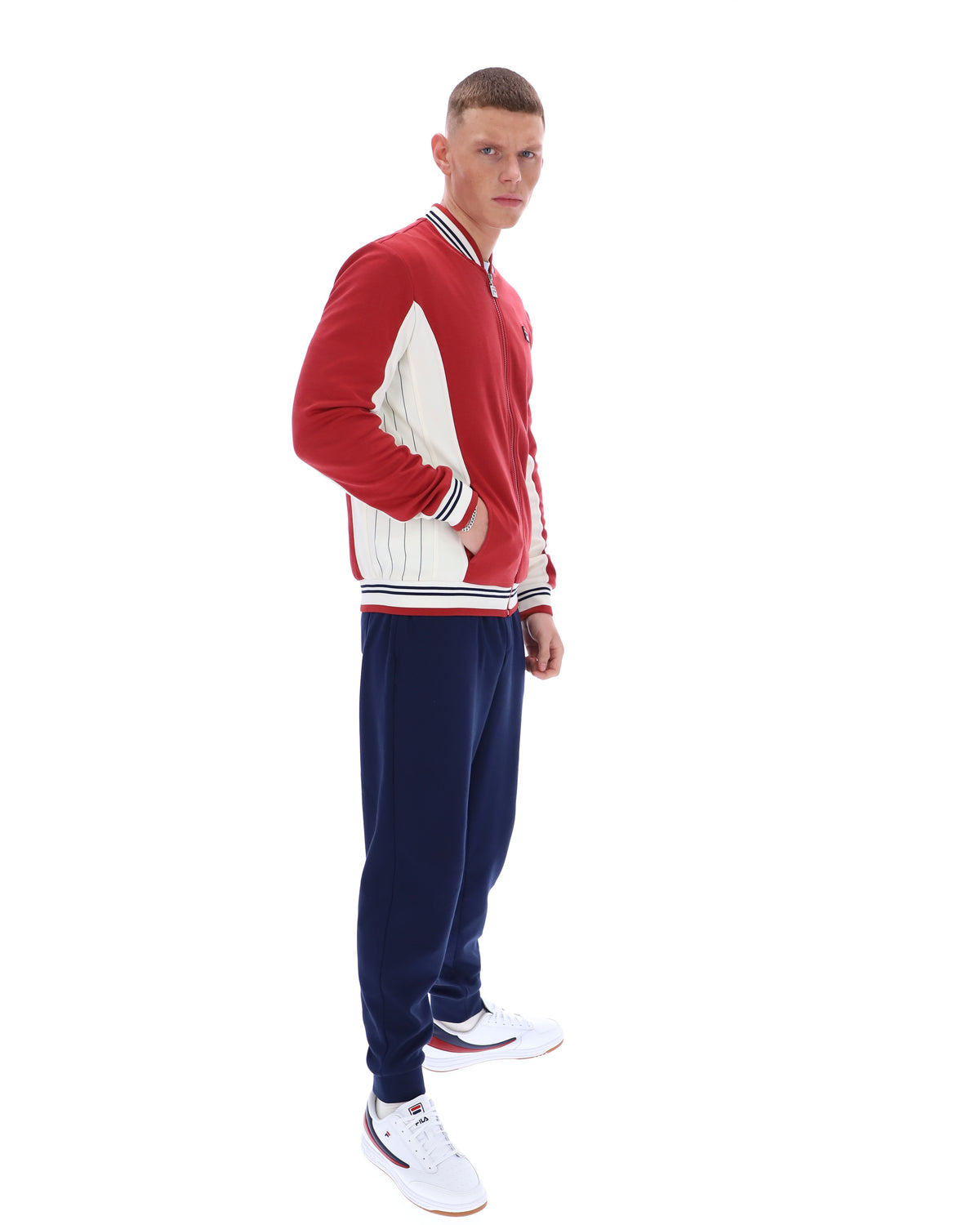 Man wearing a red and navy tracksuit on a white background