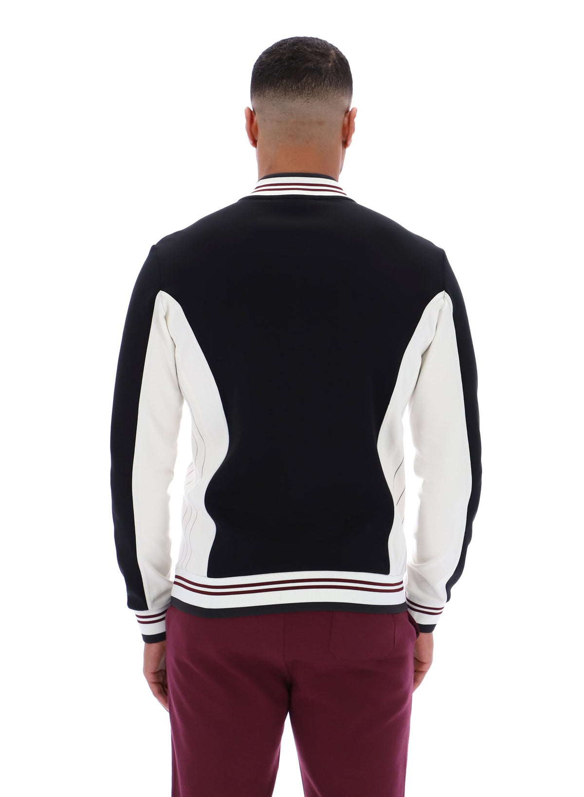 Person wearing a black and white varsity jacket on a white background