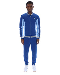 Man wearing a blue tracksuit with white accents on a white background