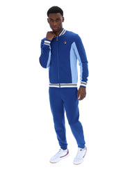 Man wearing a blue tracksuit with white accents on a white background