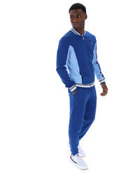 Man wearing a blue tracksuit with white accents on a white background