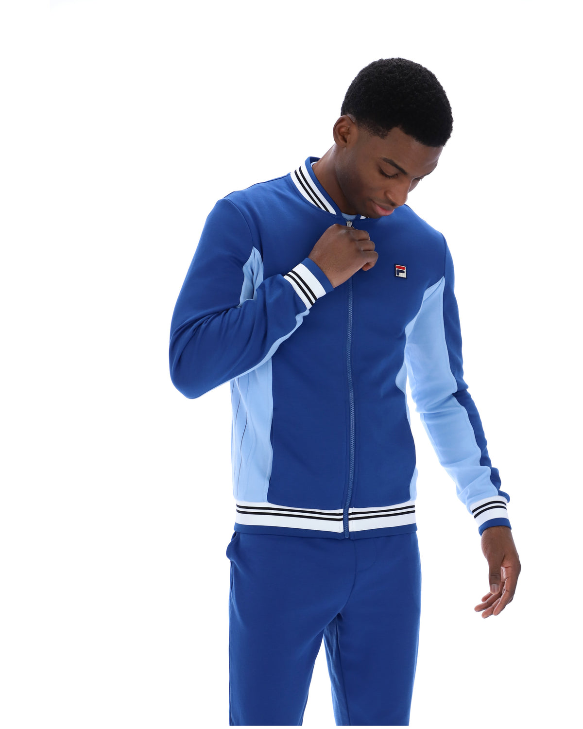 Man wearing a blue tracksuit with a white background