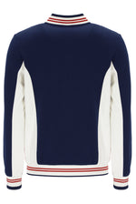 Navy and white sweater with red and white striped trim on a white background