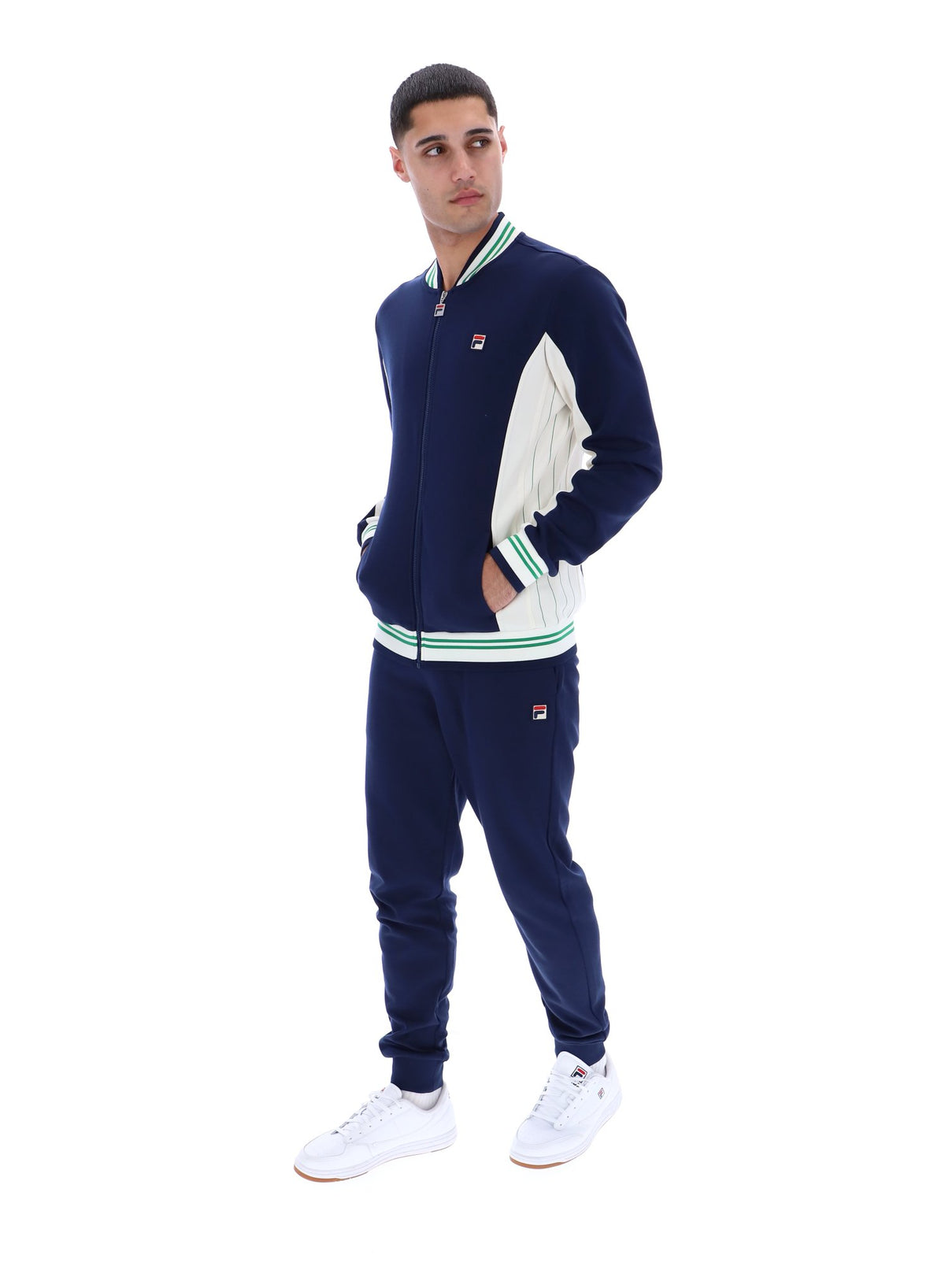 Man wearing a navy and white track top with a FILA logo on the chest, paired with matching joggers, on a white background