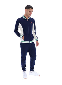 Man wearing a navy and white track top with a FILA logo on the chest, paired with matching joggers, on a white background