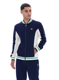 Man wearing a navy and white track top with a FILA logo on the chest, paired with matching joggers, on a white background