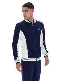 Man wearing a navy and white track top with a FILA logo on the chest, paired with matching joggers, on a white background