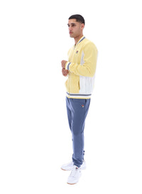 Man wearing a yellow and blue tracksuit on a white background