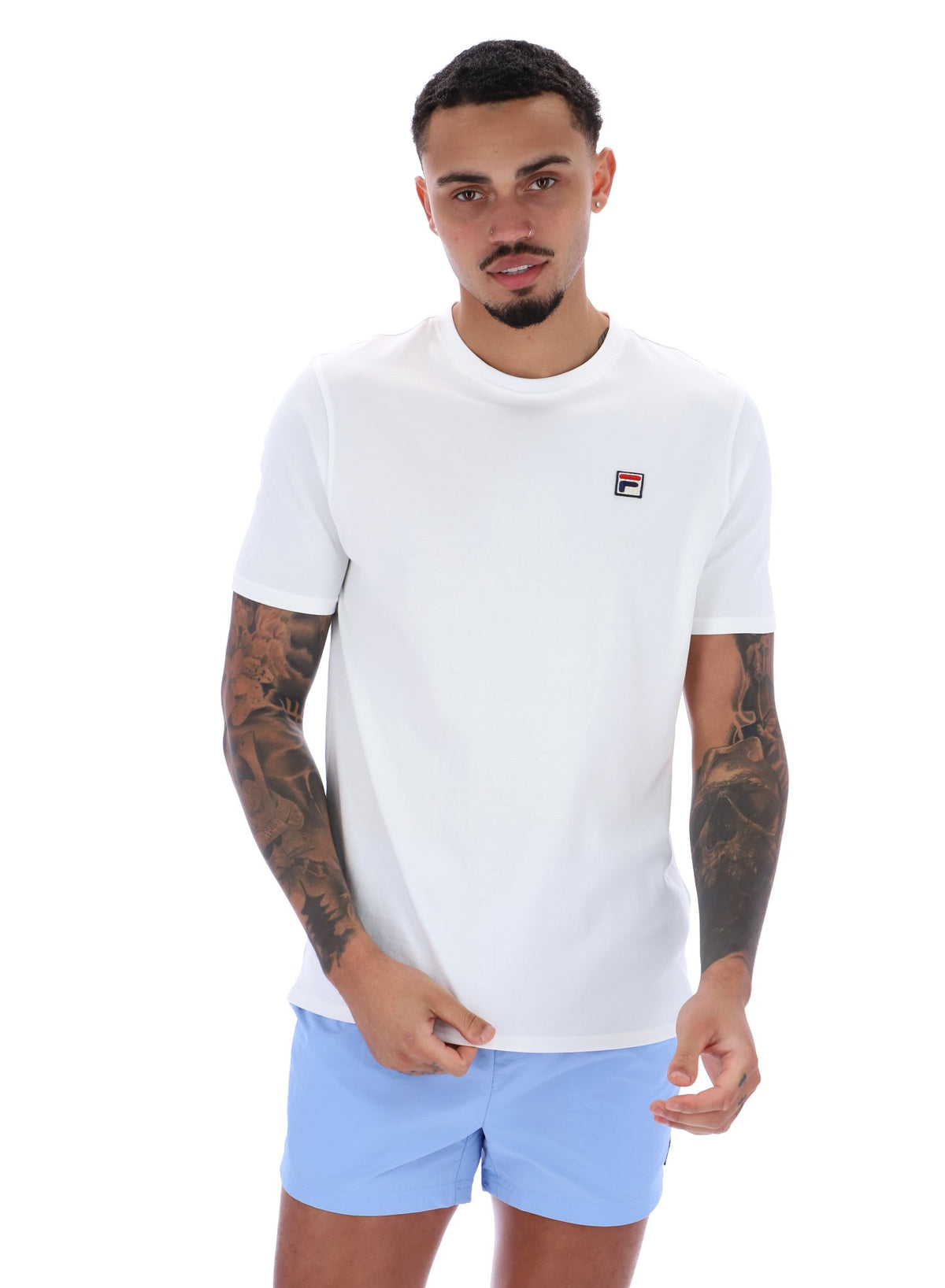 Man wearing a white t-shirt with a logo and light blue shorts on a white background
