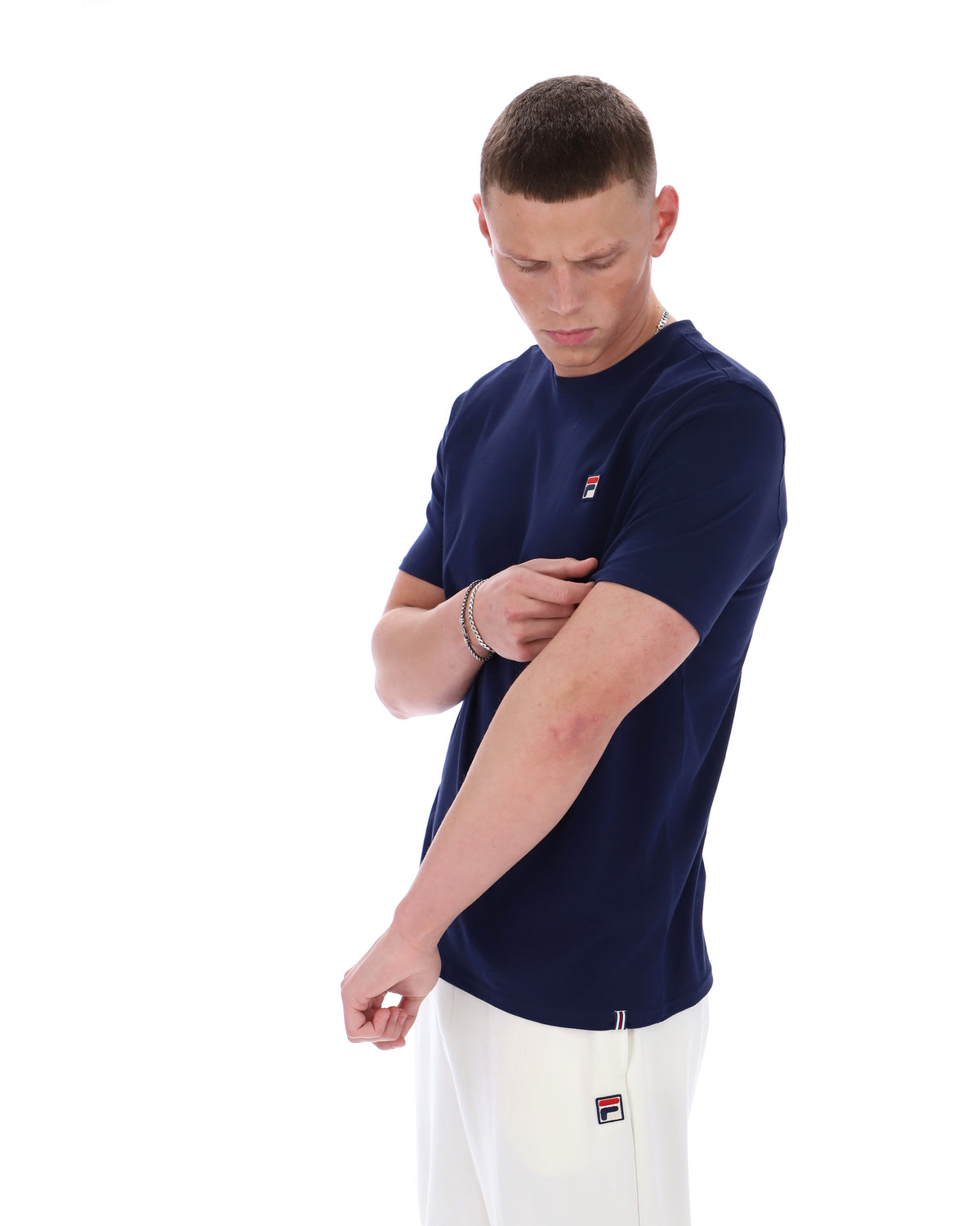Man wearing a navy blue t-shirt with a logo on a white background
