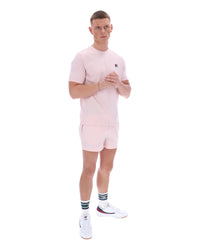 Man wearing a pink outfit with a logo on a white background