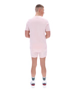 Person wearing a light pink outfit with white shoes on a white background