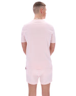 Person wearing a light pink t-shirt and shorts set on a white background