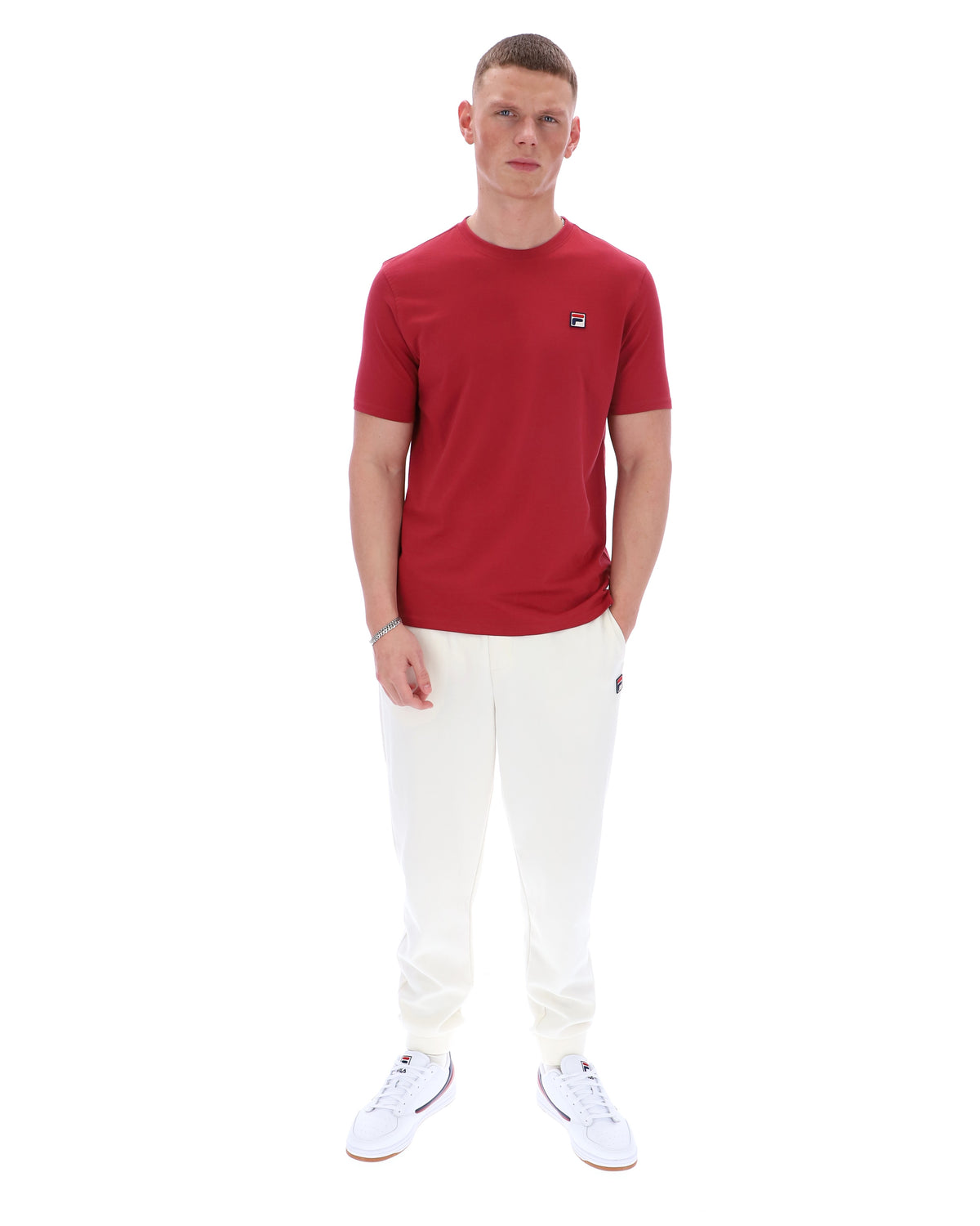 Man wearing a red t-shirt and white pants on a white background