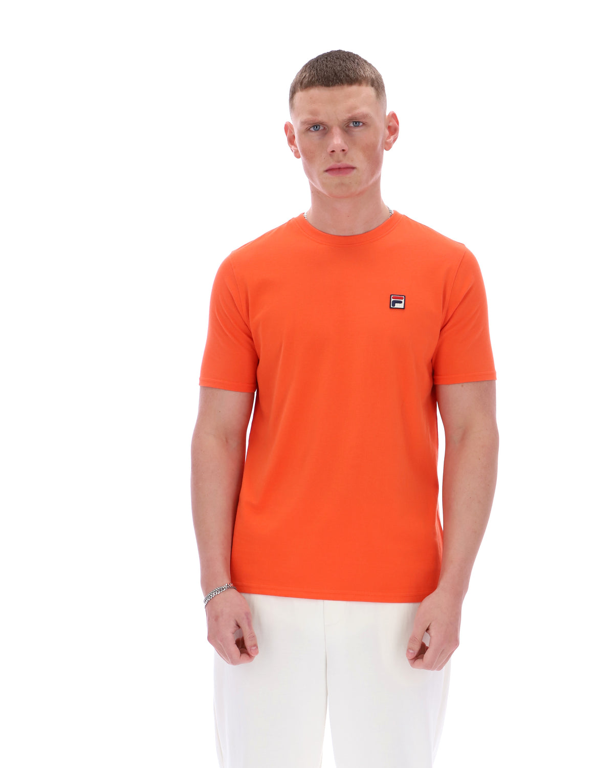 Man wearing an orange t-shirt with a small logo on a white background