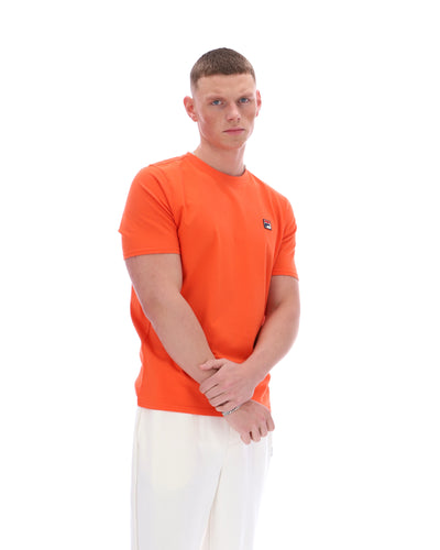 Man wearing an orange t-shirt with a logo on a white background