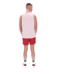 Person wearing a pink tank top and red shorts on a white background