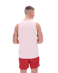 Man wearing a light pink sleeveless shirt and red shorts on a white background