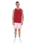 Man wearing a red sleeveless shirt and pink shorts on a white background
