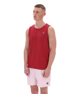 Man wearing a red sleeveless shirt and pink shorts on a white background