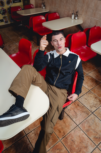 Displays a model wearing the Dark Olive 'FILA' branded Oscar Cargo Pants