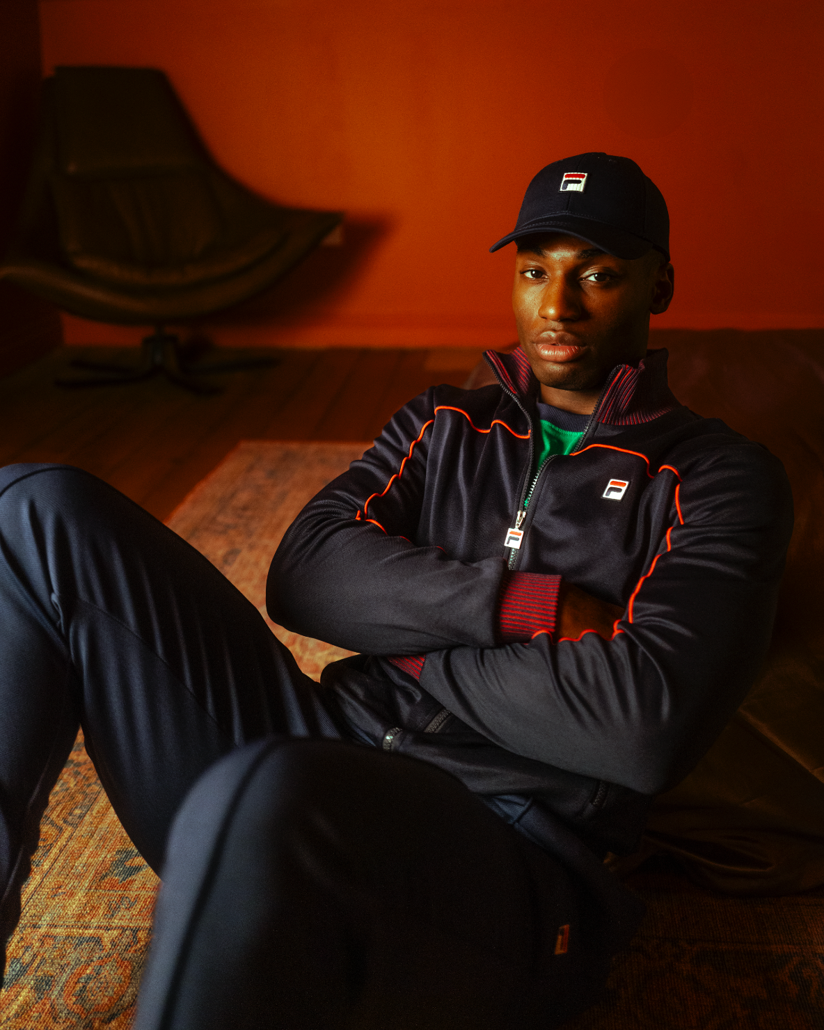 Displays a model wearing the Navy 'FILA' branded Zayn Track Top