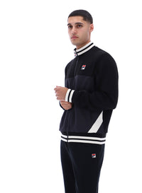 Person wearing a black tracksuit with white accents and FILA logo on a white background