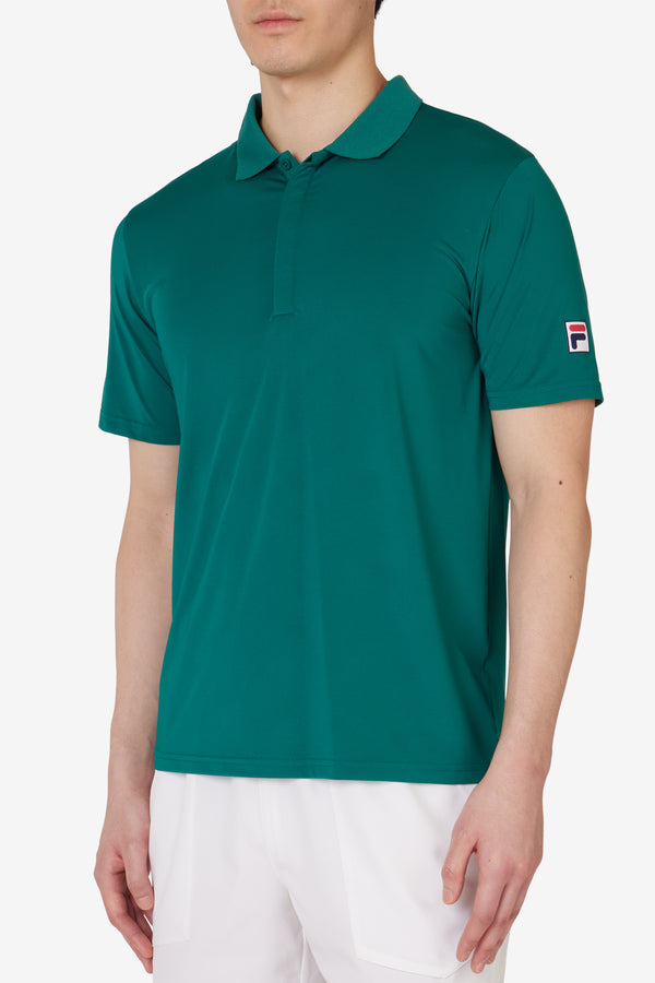 Displays a model wearing the Green 'FILA' branded Tennis Essentials Top