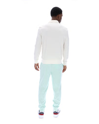 Man wearing a white sweater and light blue pants on a white background