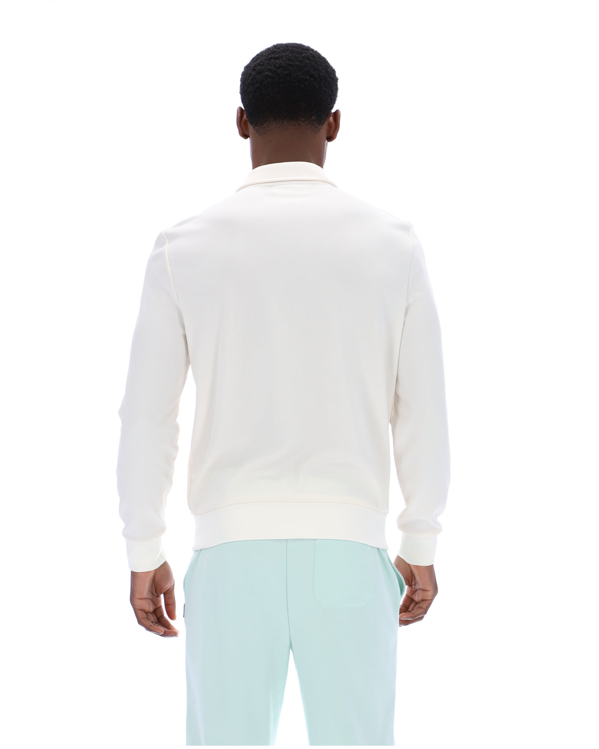 Person wearing a white sweater and light blue pants on a white background