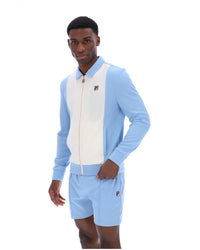 Man wearing a light blue tracksuit with a white panel and a visible brand logo on a white background