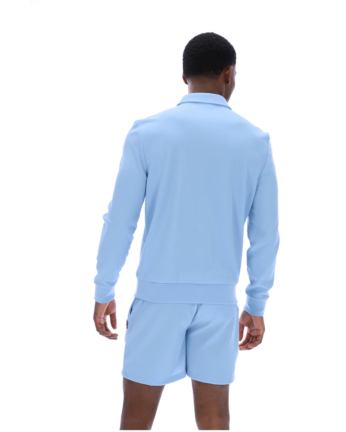 Person wearing a light blue long-sleeve shirt and shorts set on a white background