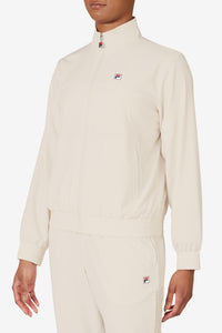 Displays a model wearing the Beige 'FILA' branded Tennis Advantage Track Top