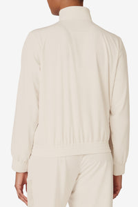 Displays a model wearing the Beige 'FILA' branded Tennis Advantage Track Top