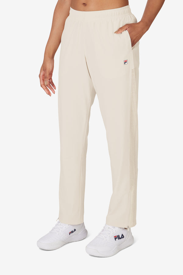 Displays a model wearing the Beige 'FILA' branded Tennis Advantage Track Pant
