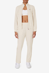 Displays a model wearing the Beige 'FILA' branded Tennis Advantage Track Pant