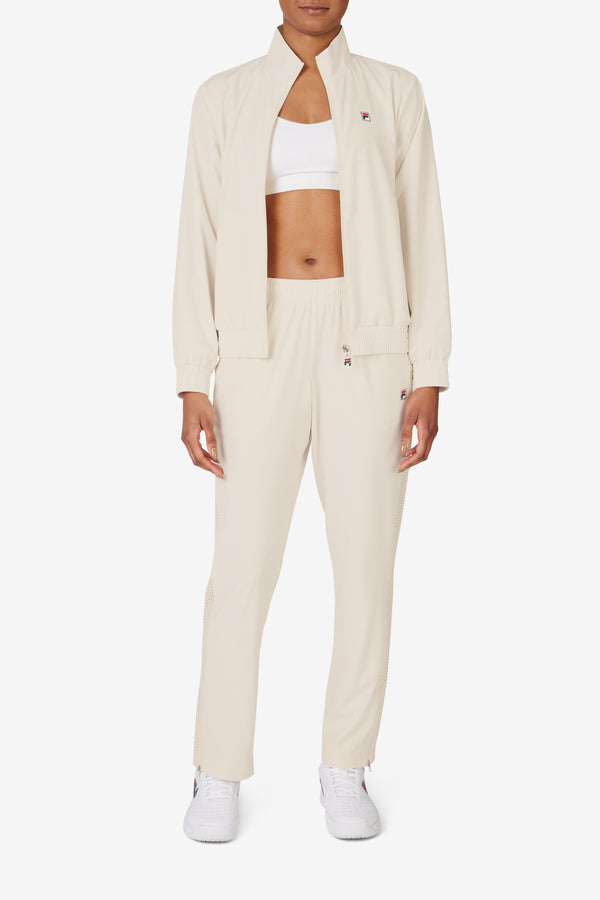 Displays a model wearing the Beige 'FILA' branded Tennis Advantage Track Pant