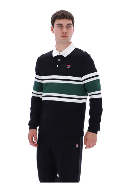 A man wearing a vintage Fila long-sleeve rugby shirt in black with green and white horizontal stripes, paired with black trousers, against a plain white background.