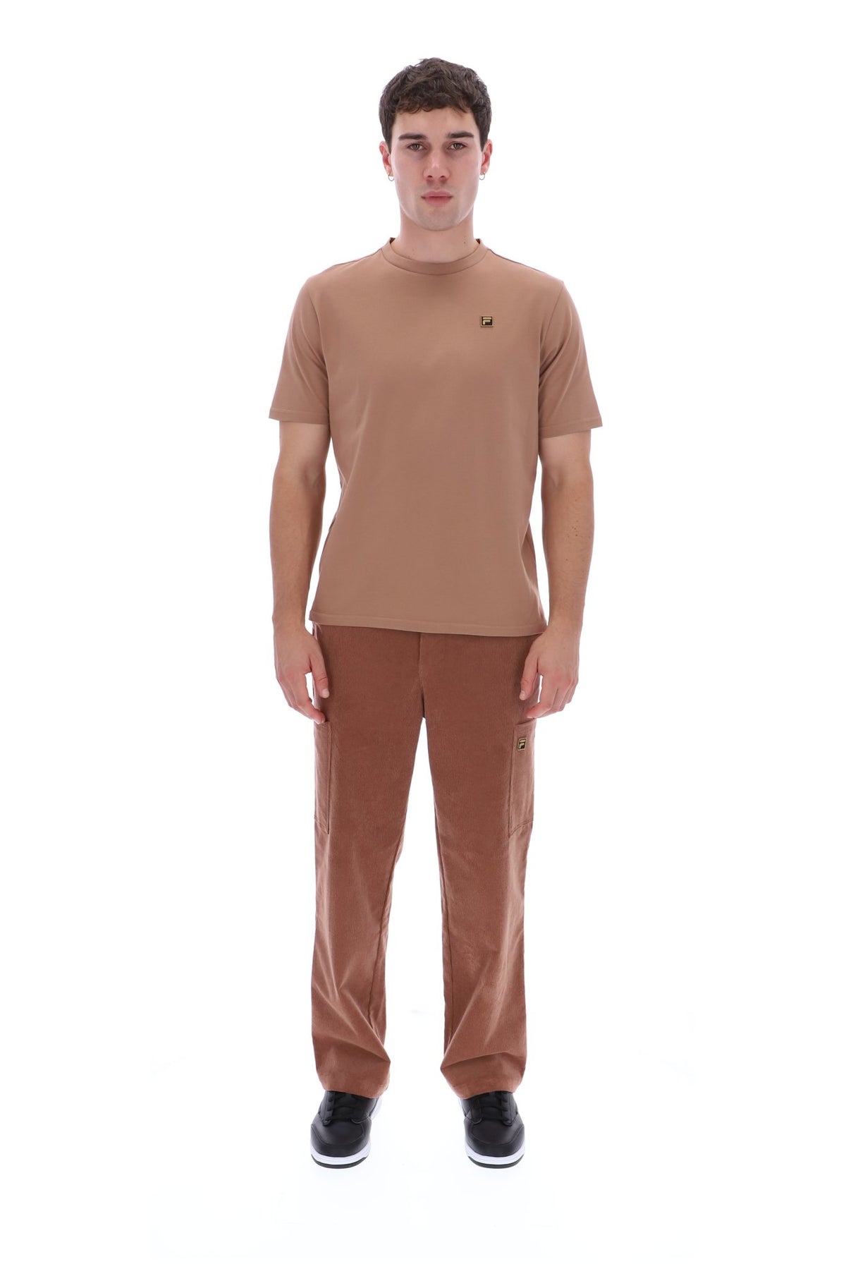A man modeling a brown short-sleeve crewneck t-shirt and matching brown pants against a solid white background.
