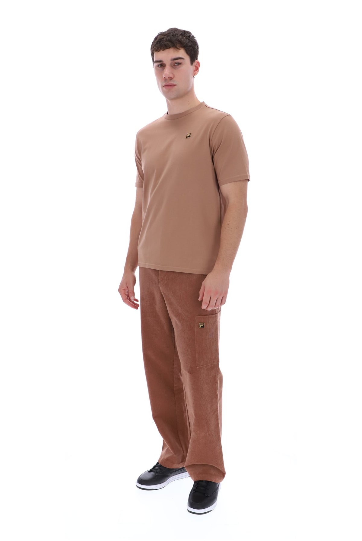 A man modeling a tan short-sleeve crewneck t-shirt and matching brown cargo pants against a solid white background.