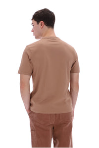 A man shown from the back wearing a short-sleeve crewneck t-shirt in a warm tan shade and brown pants, set against a plain white background.