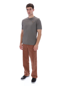A man modeling a short-sleeve crewneck t-shirt in dark gray and brown corduroy trousers, standing against a solid white background.