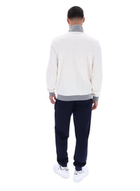 Displays a model wearing the Gardenia 'FILA' branded Zayn Track Top