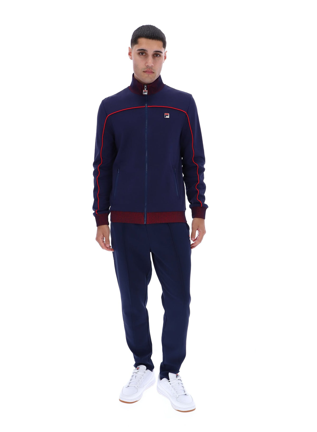 Displays a model wearing the Navy 'FILA' branded Zayn Track Top