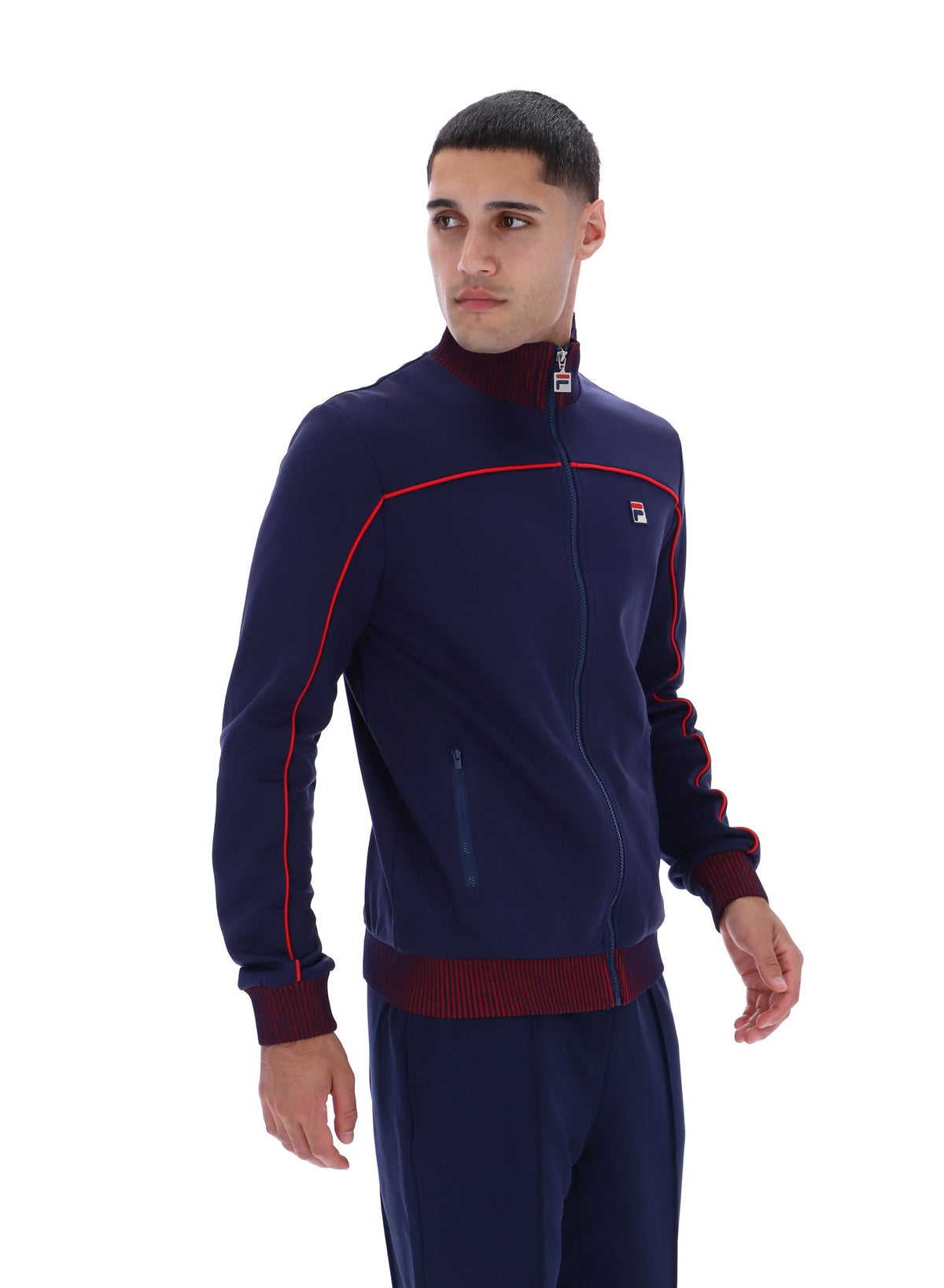 Displays a model wearing the Navy 'FILA' branded Zayn Track Top