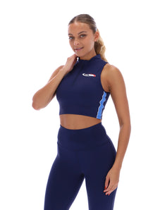 A woman wearing a navy blue zip-up crop top with seamless look and FILA x TALA logo branded on the front.